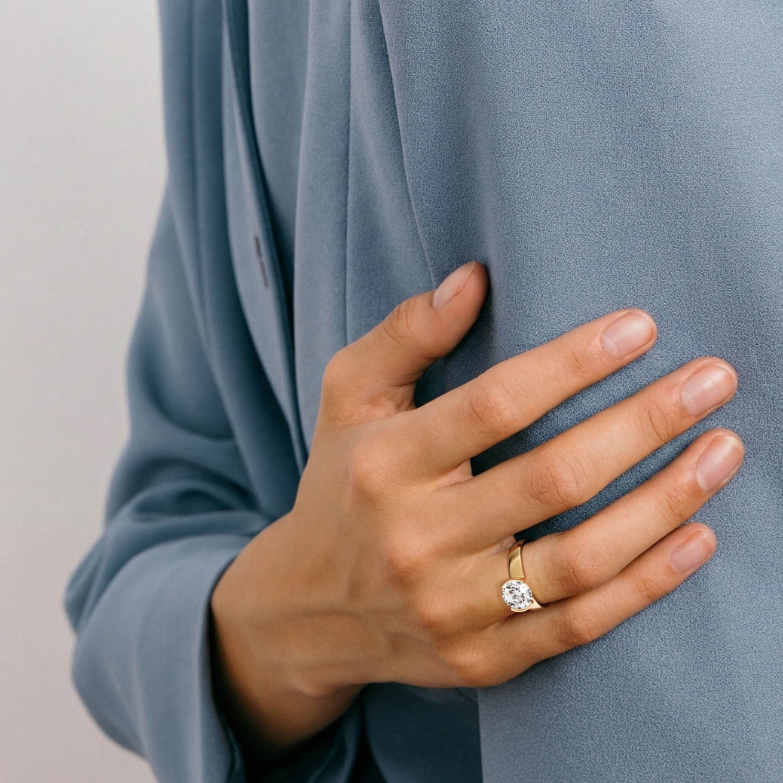 Miri round diamond tapered bezel engagement ring worn on hand