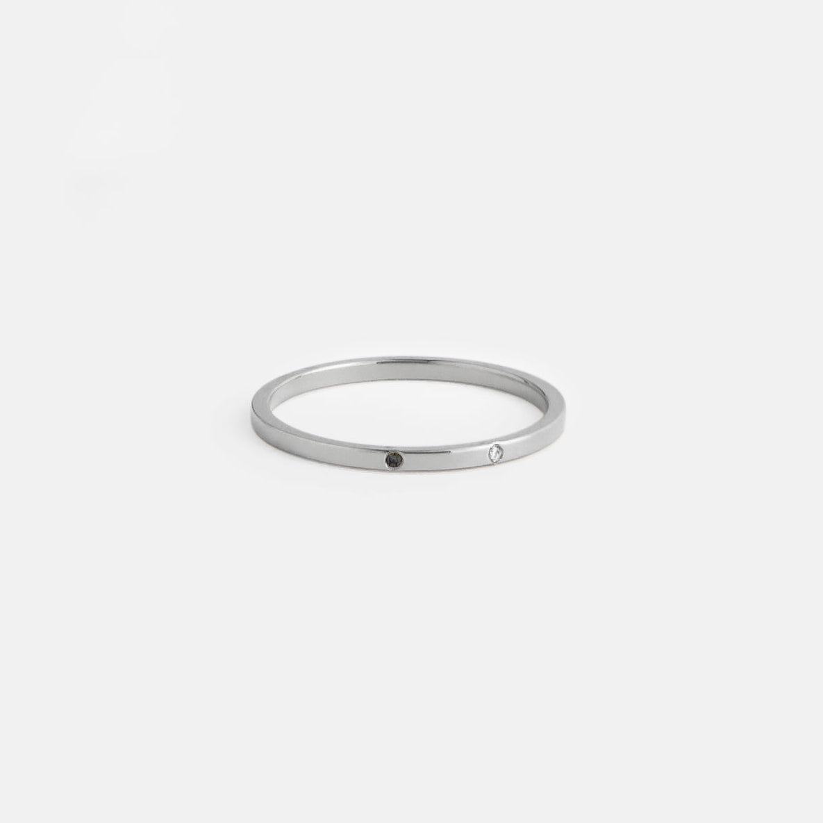 14k white gold flat profile band with one white and one black diamond