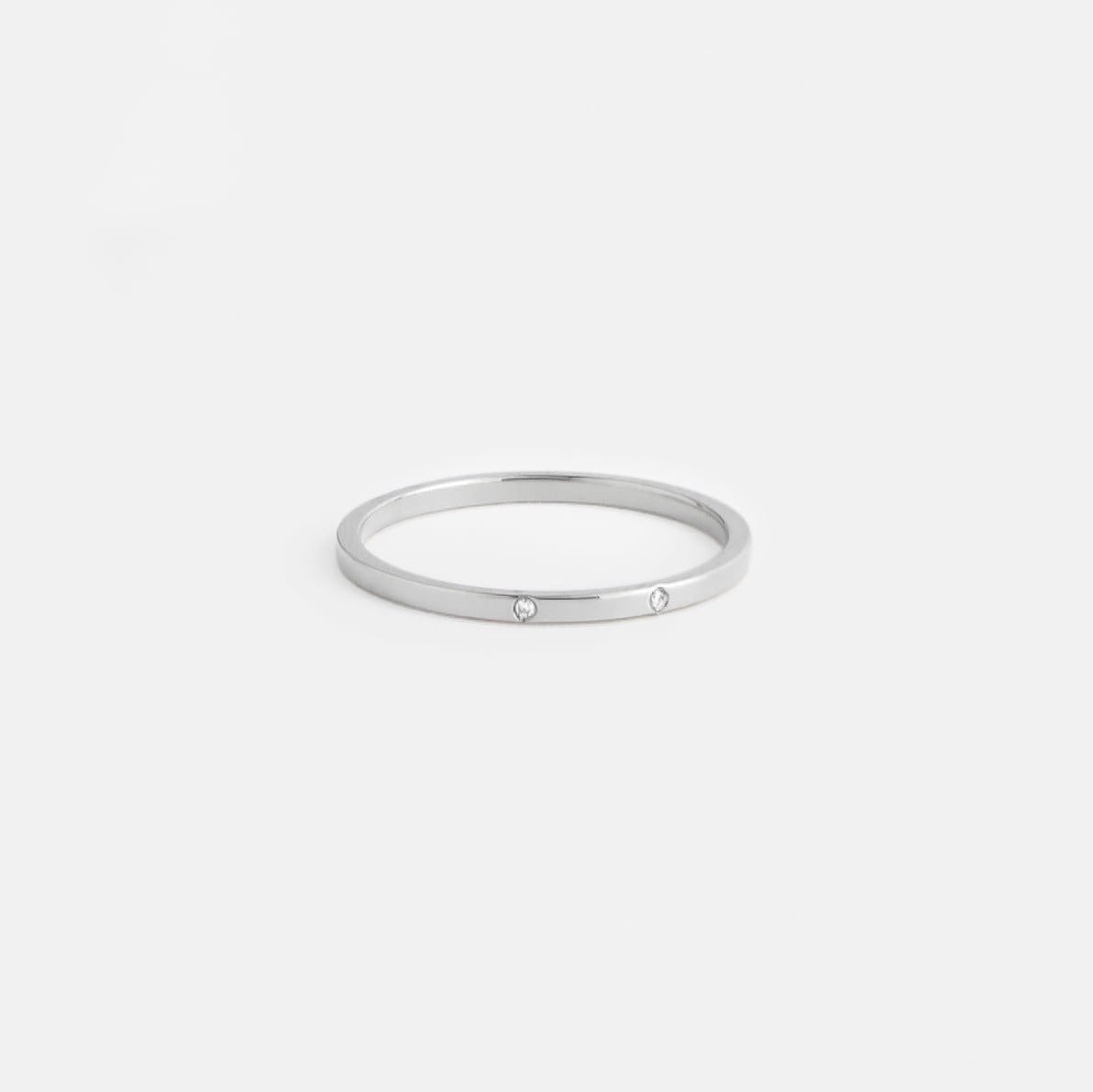 silver delicate wedding band with two round white diamonds